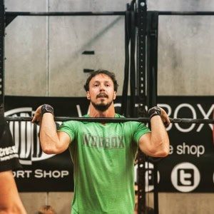 Hombre haciendo ejercicio de press militar en Box 1315 Crossfit Málaga.