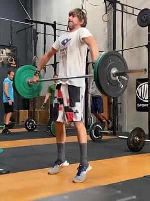 Hombre levantando peso en entrenamiento de CrossFit en Málaga.