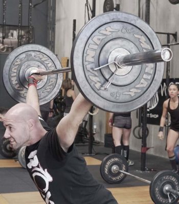 Persona levantando pesas en gimnasio CrossFit en Málaga.