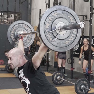 Persona levantando pesas en gimnasio CrossFit en Málaga.