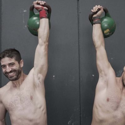Hombres haciendo levantamiento de pesas con kettlebells en Málaga.