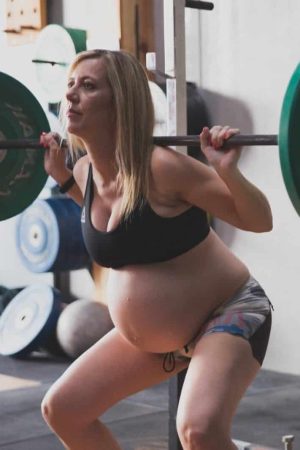 Mujer embarazada haciendo sentadillas con barra en Box 1315 Crossfit Málaga.